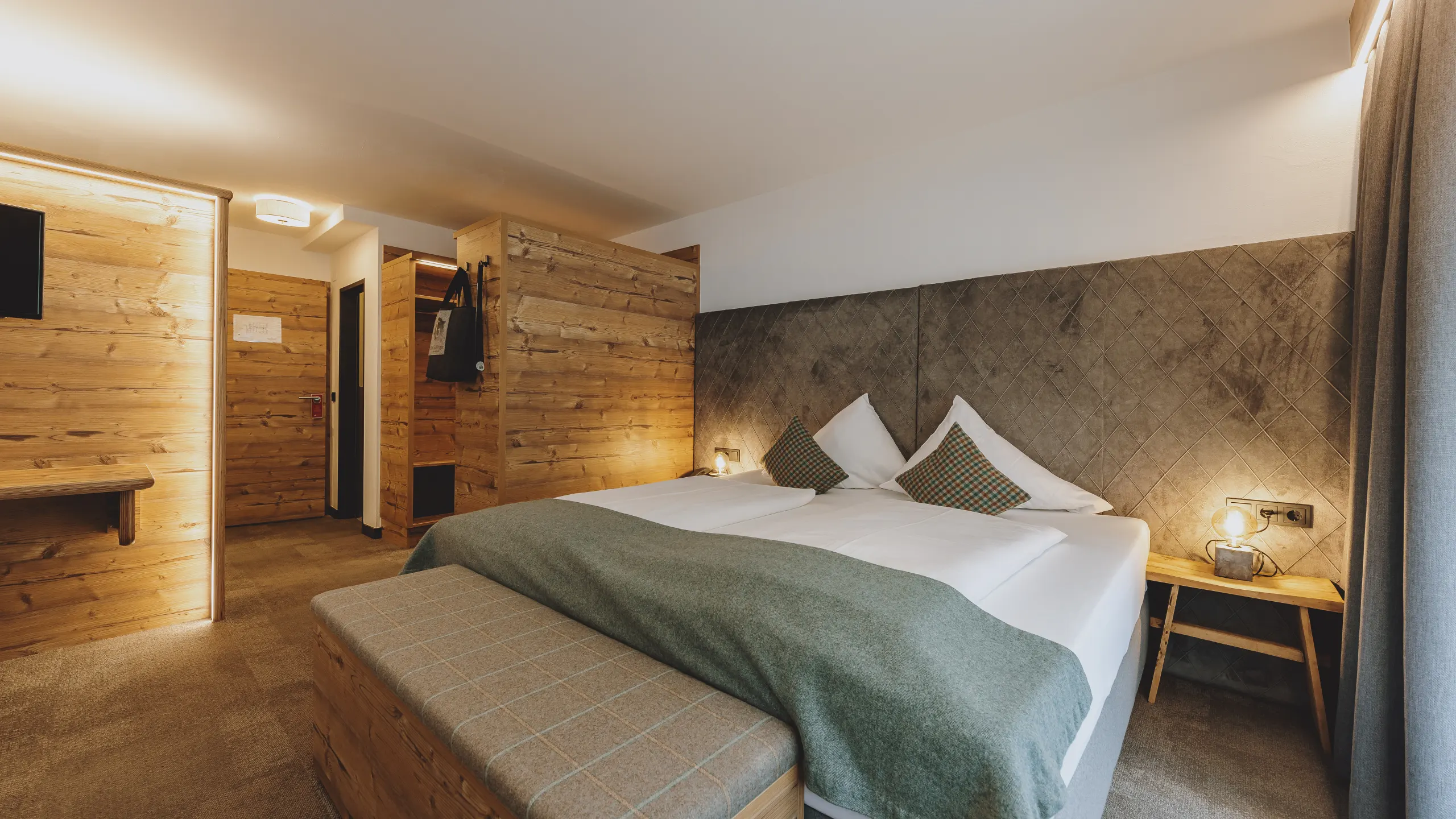 Helles Hotelzimmer mit Holzdetails und einem Doppelbett