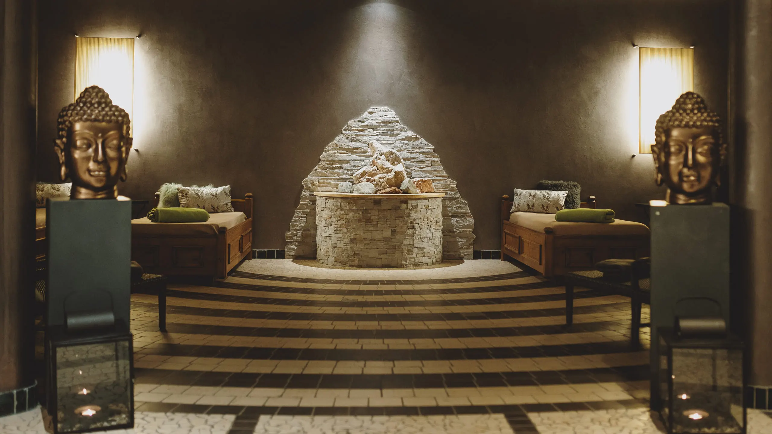 In a spa area with a water feature, Buddha statues, and seating.