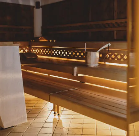 Wooden sauna with benches and a scoop on the table