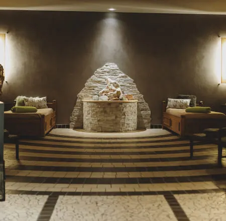 Cozy seating areas with a stone fountain and illuminated walls.