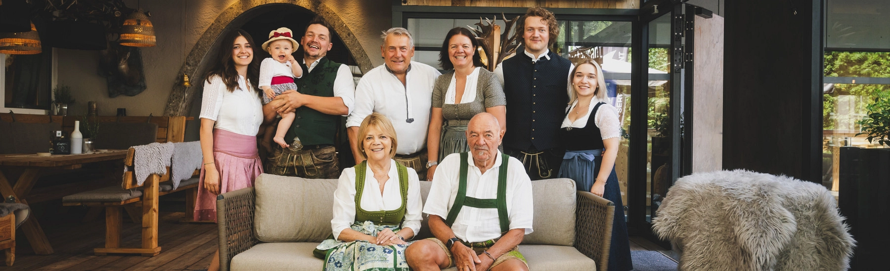 Familie posiert in traditioneller Kleidung in gemütlichem Innenraum
