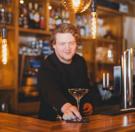 Bartender serviert einen Cocktail an der Bar