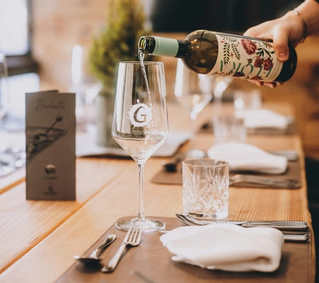 Tischgedeck im Restaurant Max Moritz mit Weinflasche und Gläsern