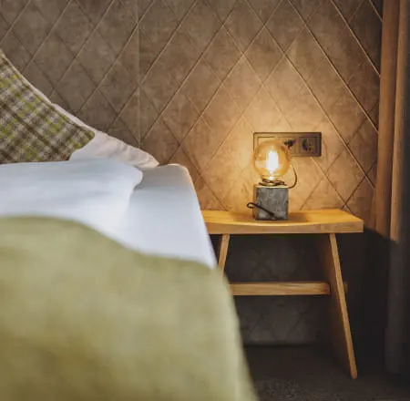 Room detail with bed, pillow, and lamp on a table
