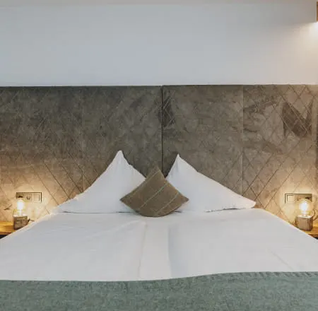 Detail view of a bedroom with a bed and modern nightstands