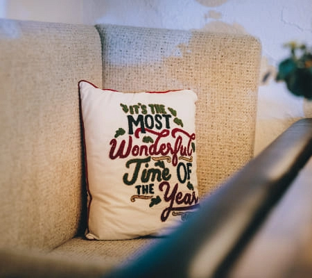 Sofa mit einem Kissen, auf dem steht: 'Es ist die wundervollste Zeit des Jahres'