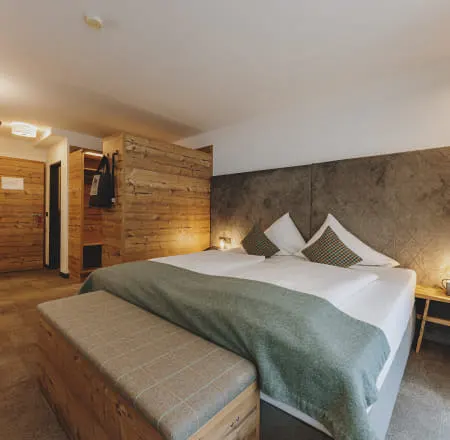 Modern room with wooden details, bed and bench.