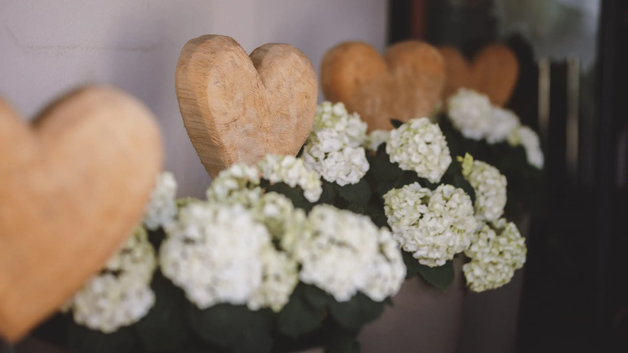 Holzherz-Dekorationen mit weißen Blumen