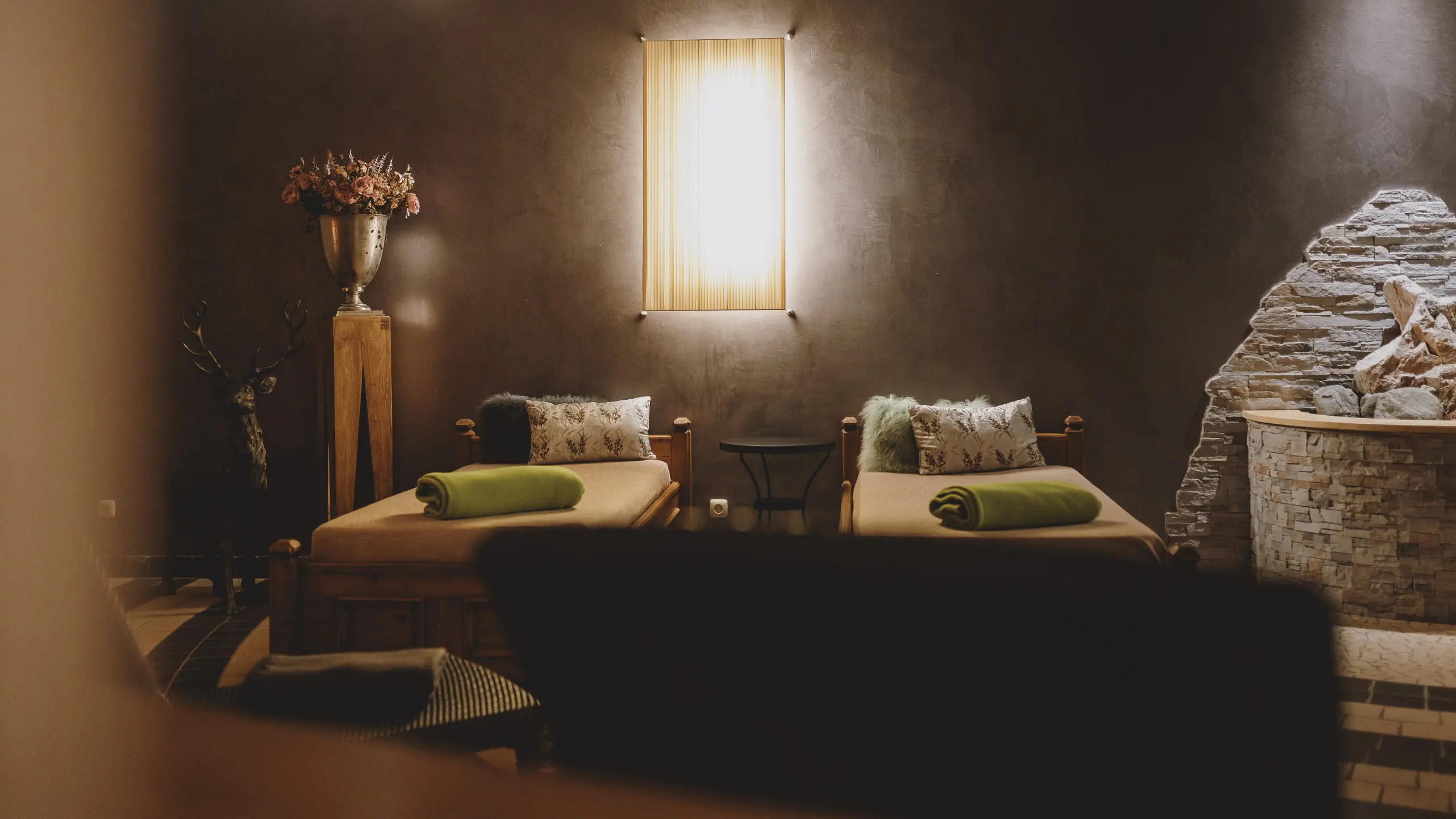 Wellness area with cozy lounge chairs and a stone fireplace.