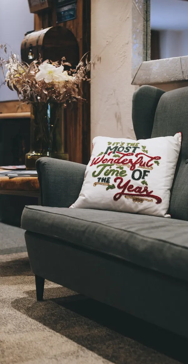 Cozy living room corner with a decorative pillow and flowers