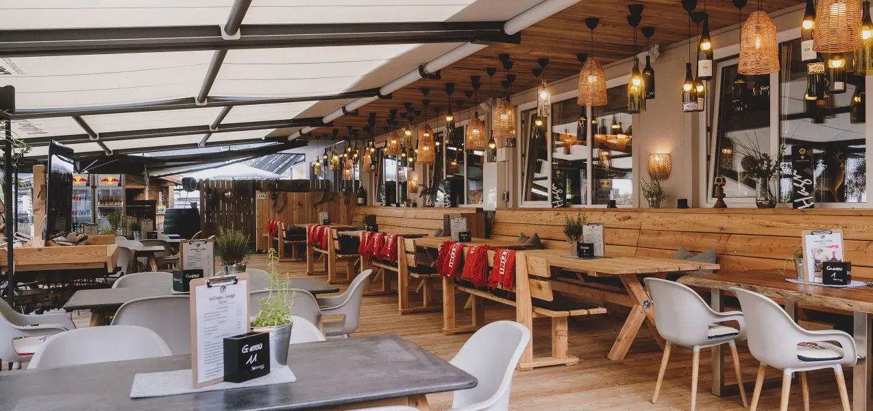 Modern lounge with wood decor and lights, tables and chairs.