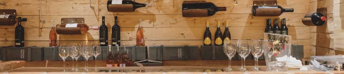 Wooden wall with wine bottles and glasses on the counter