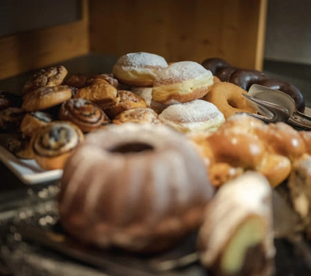 Eine Auswahl an süßen Backwaren, einschließlich Donuts und Zimtrollen.
