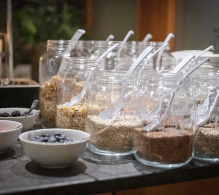 Gläser mit verschiedenen Körnern und Schalen mit Beeren auf einer Küchenarbeitsfläche