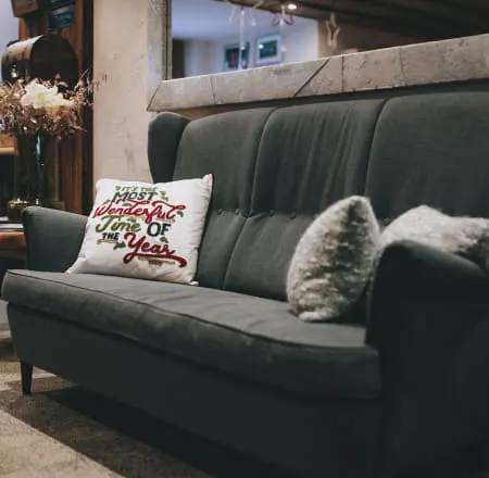Gemütliches graues Sofa mit Kissen und Dekoration im Hintergrund