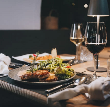 Table with various dishes, wine, and a lamp.