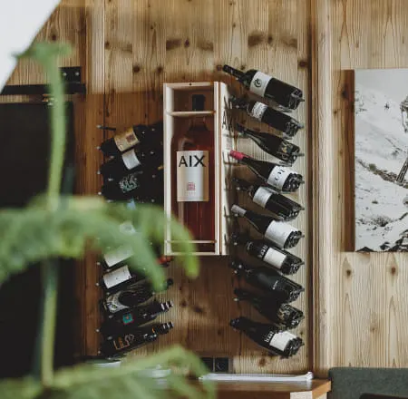 Weinregal mit mehreren Flaschen und einem Kunstwerk an der Wand