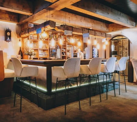 Moderne Bar mit Holzdekor, einladend, und beleuchtetem Tresen.