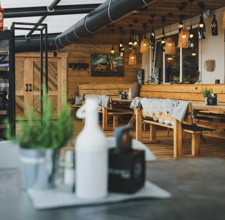 Innenansicht eines gemütlichen Restaurants mit Holzmöbeln und dekorativen Lichtern