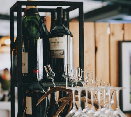 Shelf with wine bottles and glasses at Max Moritz restaurant