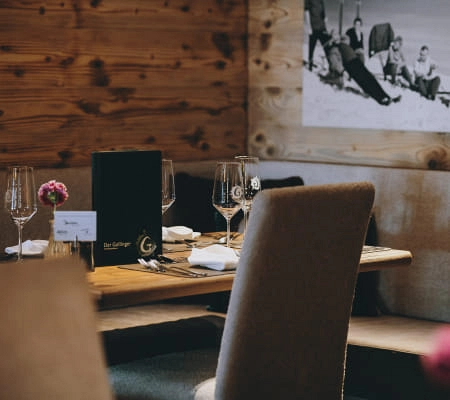 Gemütlicher Restauranttisch mit Menükarten und Blumen in Holzinterieur