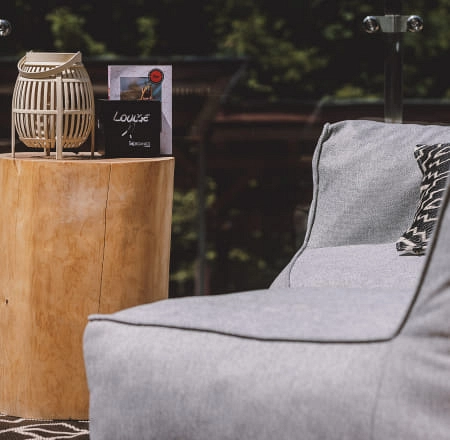 Holztisch mit Lampe und Broschüre in einer Lounge-Umgebung