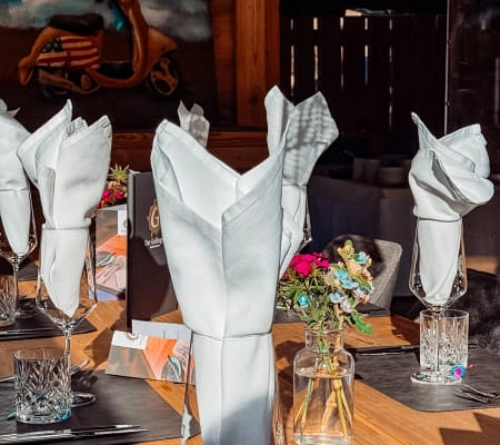 Table setting with white napkins and flower arrangement