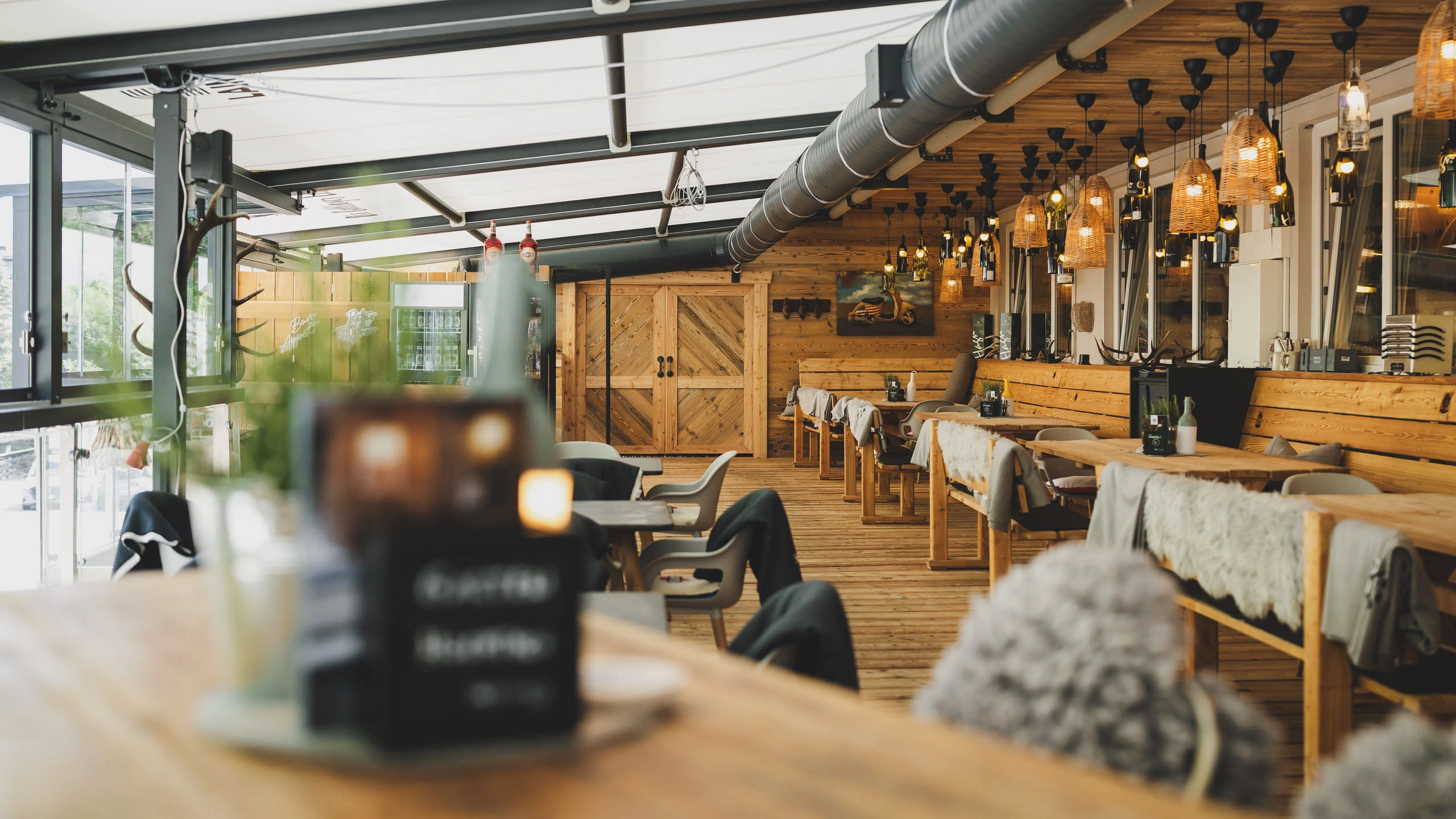 Innenansicht eines Restaurants mit Holzmöbeln und Beleuchtung