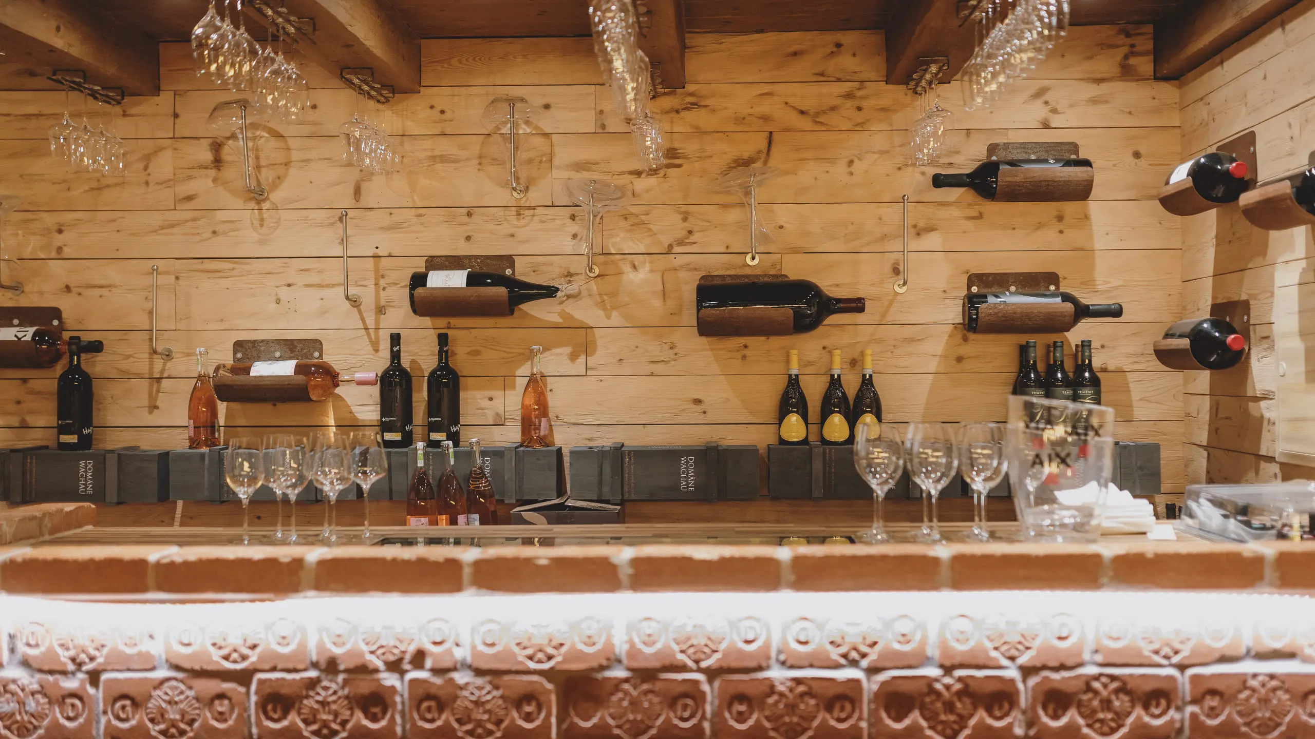 Holzwand mit Weinflaschen und Gläsern in einer Weinlounge