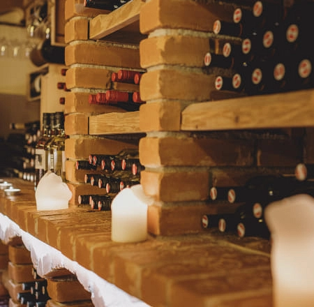 Regal mit Weinflaschen und Kerzenlicht in der Weinlounge