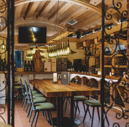 Gemütliche Weinlounge mit Holzregalen und Tisch für Weinverkostungen