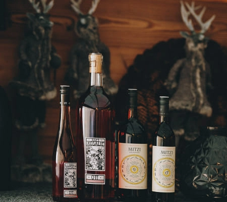 Flaschen mit alkoholischen Getränken vor dekorierten Weihnachtsfiguren