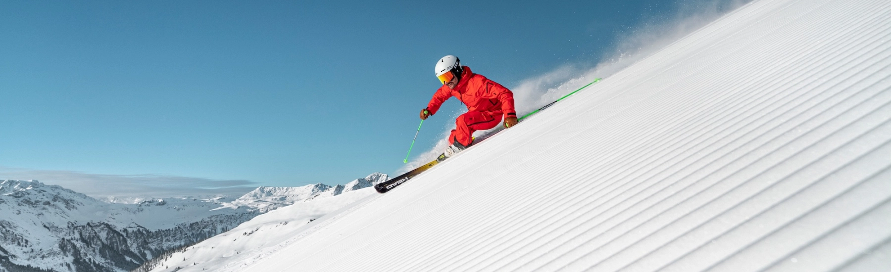 Skifahrer im roten Anzug auf einer verschneiten Piste von Skicircus Saalbach-Hinterglemm.