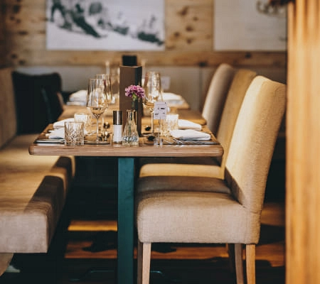 Innenansicht des Der Gollinger Restaurants mit gedeckten Tischen und gemütlichen Stühlen