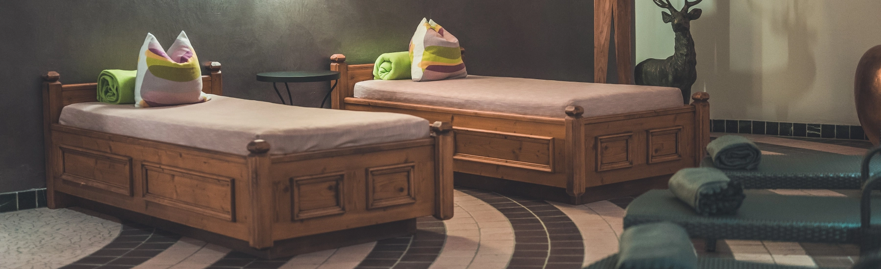 Zwei Holzbetten mit Kissen in einem Spa-Bereich.