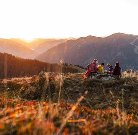 Wanderer genießen den Sonnenuntergang in Saalbach Hinterglemm
