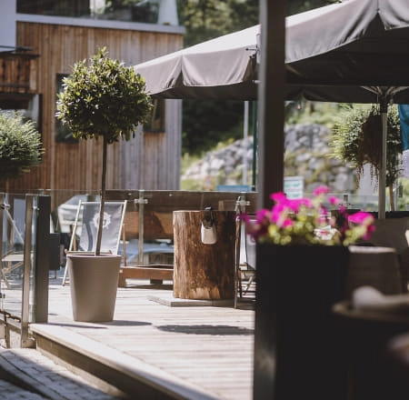 Terrasse mit Holzpflanzgefäßen und Gartenmöbeln