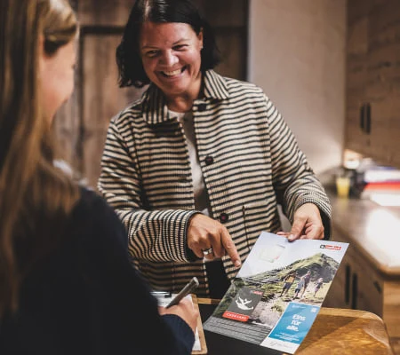 Zwei Frauen besprechen eine Broschüre über die Region Der Gollinger