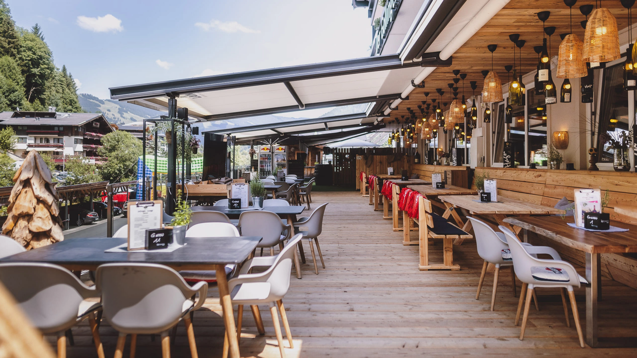 Außenterrasse eines Restaurants mit Holz-Tischen und Stühlen